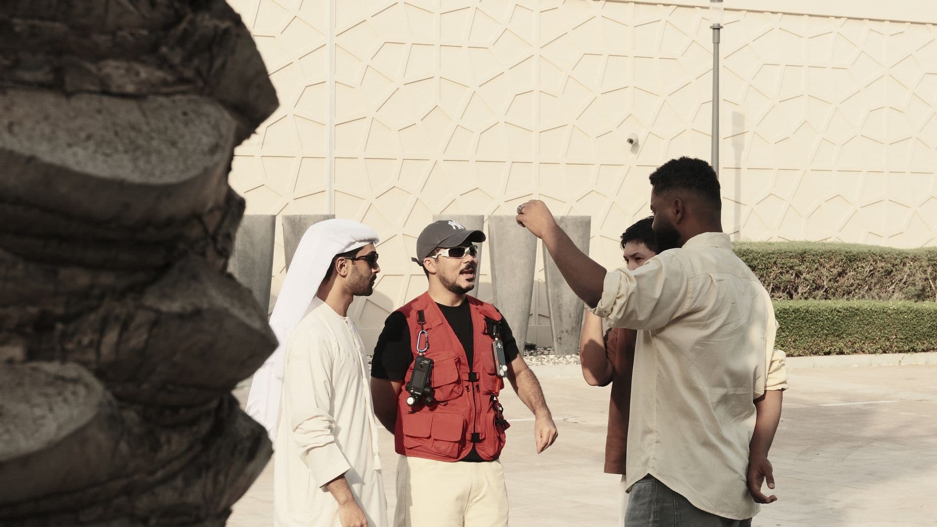 Crew and cast outside a white building